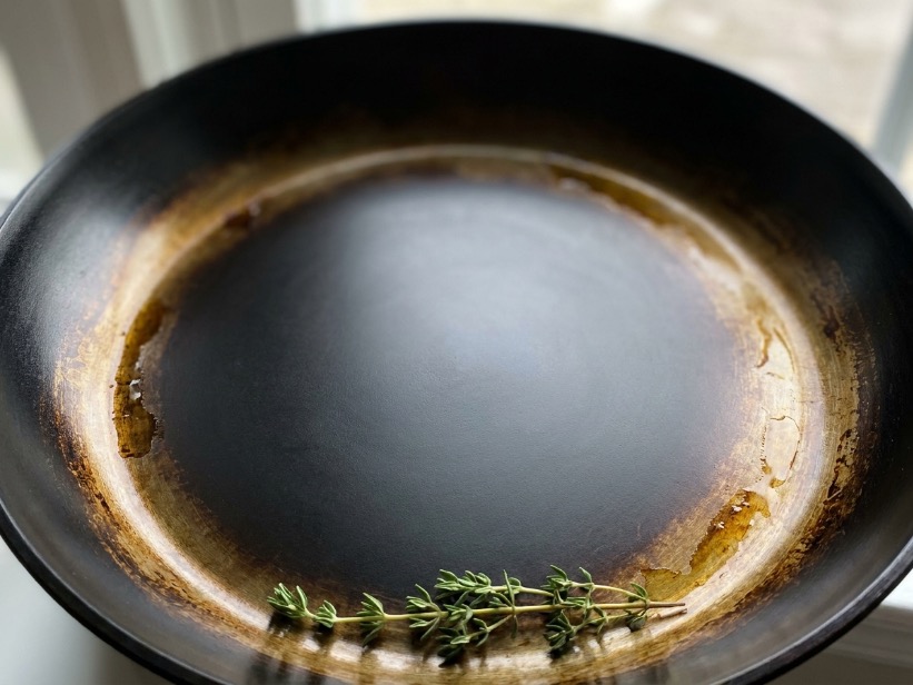 Close-up of seasoned carbon steel cooking surface showing even dark patina from use