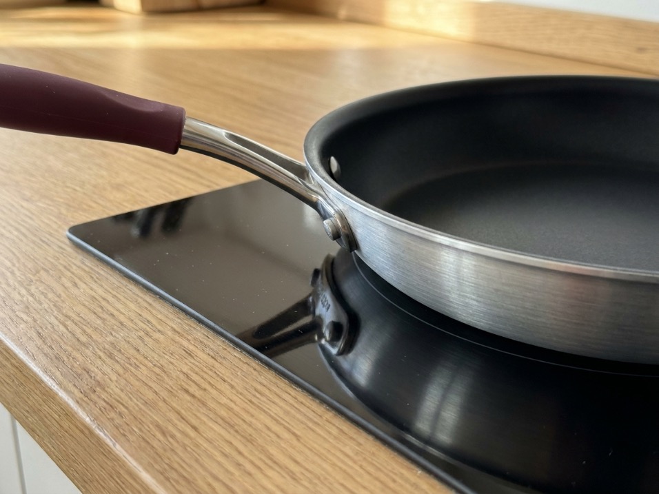 Nonstick frying pan sitting flat on glass ceramic stovetop showing no warping