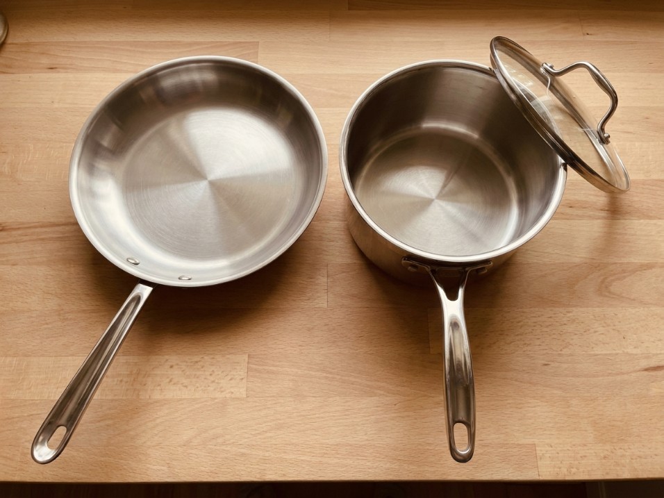 Stainless steel skillet and a taller stainless saucepan side by side on a kitchen counter