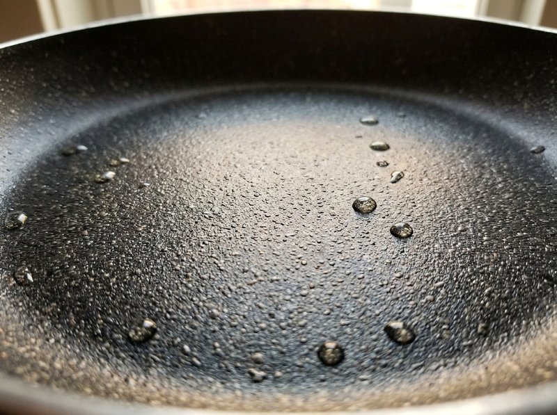 Close-up of speckled gray Granitium nonstick coating texture on an aluminum fry pan surface